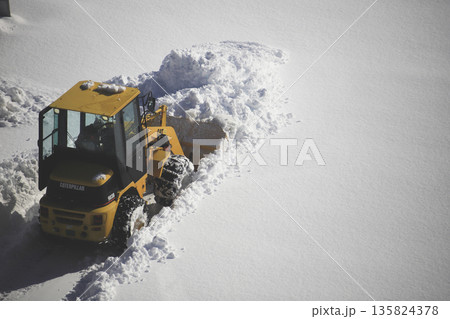 雪に覆われた駐車場を除雪する除雪車両 雪に覆われた駐車場を除雪する除雪車両 135824378
