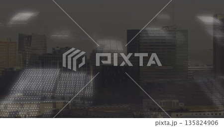 Framing high-rise office window reflecting ceiling lights grid over layered skyline, glass facades 135824906