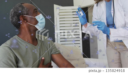 Nurse injecting masked patient with vaccine syringe on exam couch with network icons, copy space 135824918