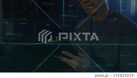 Monitoring data overlays, Korean IT tech with lanyard tapping tablet among server racks, copy space Monitoring data overlays, Korean IT tech with lanyard tapping tablet among server racks, copy space 135825019