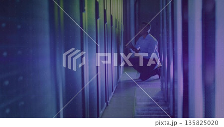 Kneeling African American technician inspecting server rack with LEDs in data center, with tablet Kneeling African American technician inspecting server rack with LEDs in data center, with tablet 135825020