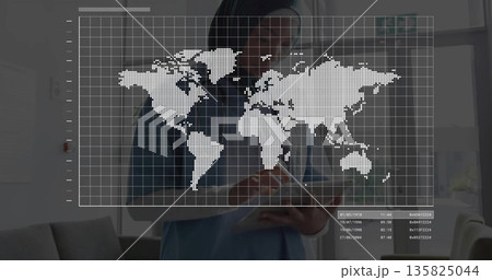 Standing doctor holding digital tablet in clinic with world map grid overlay, sofa, large windows Standing doctor holding digital tablet in clinic with world map grid overlay, sofa, large windows 135825044