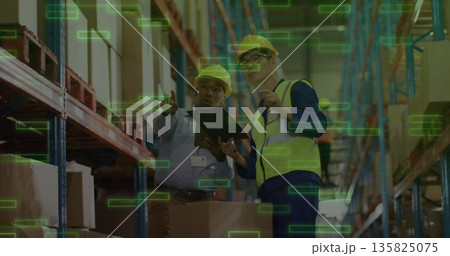 Warehouse workers scanning boxes in racks in distribution center with tablet and hard hats, vests Warehouse workers scanning boxes in racks in distribution center with tablet and hard hats, vests 135825075