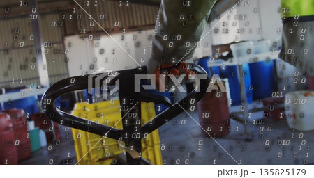 Operating warehouse worker gripping pallet jack handle amid yellow crates and red jerry cans Operating warehouse worker gripping pallet jack handle amid yellow crates and red jerry cans 135825179