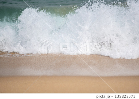 Ocean waves crashing on sandy beach Ocean waves crashing on sandy beach 135825373