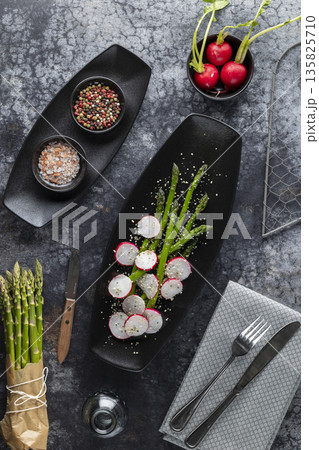 Fresh asparagus and radish salad on a black plate Fresh asparagus and radish salad on a black plate 135825710
