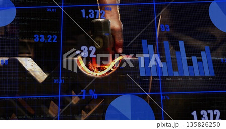 Holding glowing curved metal with tongs in gloved hand at workshop, with digital interface overlays Holding glowing curved metal with tongs in gloved hand at workshop, with digital interface overlays 135826250