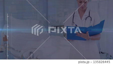 Nurse with stethoscope in scrubs writing with pen on blue clipboard at hospital bedside, copy space 135826445