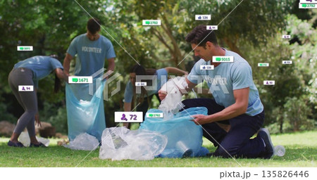 Kneeling volunteer placing plastic waste into blue trash bag in park in volunteer shirt, copy space Kneeling volunteer placing plastic waste into blue trash bag in park in volunteer shirt, copy space 135826446