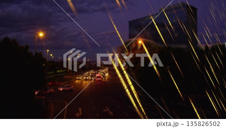 Capturing cars streaking headlights and taillights under lamps at urban intersection, with building Capturing cars streaking headlights and taillights under lamps at urban intersection, with building 135826502