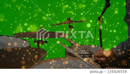 Playing denim jacket clad drummer striking drum kit in green chroma key studio, copy space 135826559