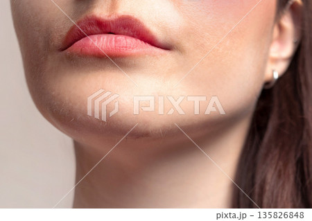 A woman mustache and beard. White hairs and dark hairs on the chin and above the lip of a woman. Close up photo A woman mustache and beard. White hairs and dark hairs on the chin and above the lip of a woman. Close up photo 135826848