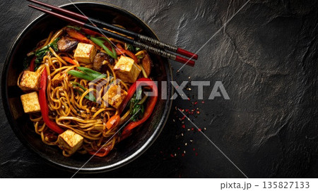 Asian stir-fried noodles with tofu and crisp vegetables in bowl 135827133