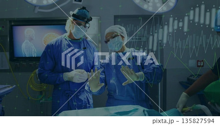 Performing surgical team manipulating instruments in hospital operating theater, with brain scan 135827594