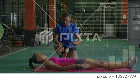Coaching male instructor guiding female client on pink mat at gym, with barbells and cable machines Coaching male instructor guiding female client on pink mat at gym, with barbells and cable machines 135827774