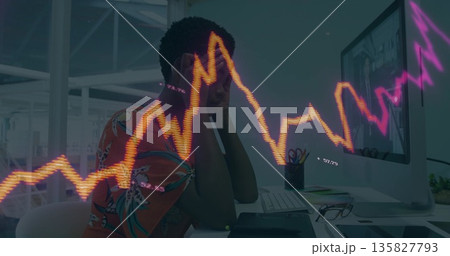 Leaning woman wearing shirt supporting head at office desk with monitor, financial graph overlay Leaning woman wearing shirt supporting head at office desk with monitor, financial graph overlay 135827793
