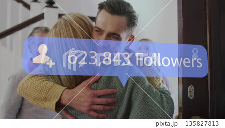Hugging man and woman wearing sweaters in home entryway, wooden door, banister, followers overlay Hugging man and woman wearing sweaters in home entryway, wooden door, banister, followers overlay 135827813
