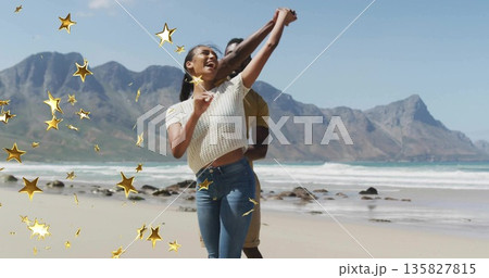 Dancing adult couple spinning on sandy beach shoreline, with decorative golden star overlays Dancing adult couple spinning on sandy beach shoreline, with decorative golden star overlays 135827815