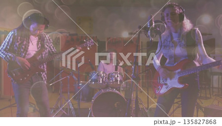 Performing three musicians playing bass, drums and electric guitar while singing into mic in studio Performing three musicians playing bass, drums and electric guitar while singing into mic in studio 135827868