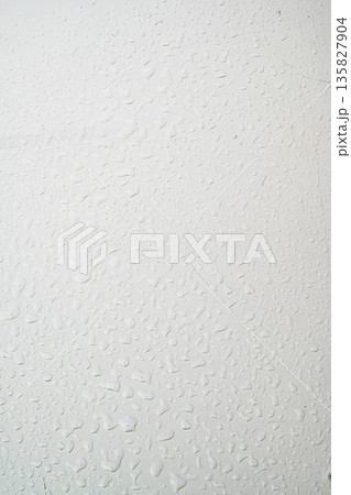 A close-up view of a gray painted surface featuring vertical liquid streaks and drips, creating a grunge industrial background for design projects 135827904