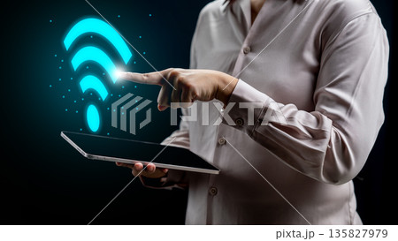 Person holding a tablet and pointing to a glowing blue Wi-Fi symbol representing high-speed internet, wireless connectivity, and digital technology networking Person holding a tablet and pointing to a glowing blue Wi-Fi symbol representing high-speed internet, wireless connectivity, and digital technology networking 135827979