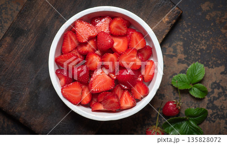 Freshly Sliced Strawberries In A White Bowl On A Rustic Background Freshly Sliced Strawberries In A White Bowl On A Rustic Background 135828072