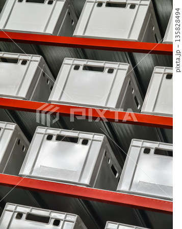 Storage containers arranged neatly on shelves in a warehouse setting for efficient organization and retrieval of items Storage containers arranged neatly on shelves in a warehouse setting for efficient organization and retrieval of items 135828494