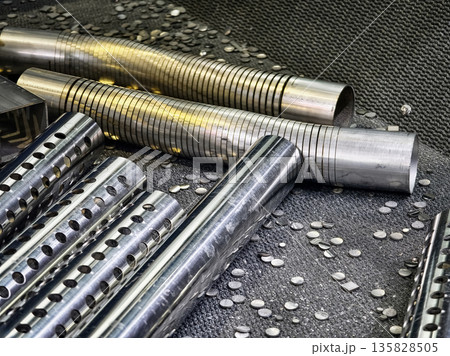 Metal rods and metal pieces on a factory floor during a production process in an industrial workshop 135828505