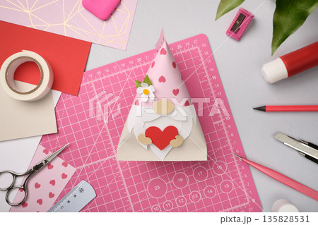 Handmade gnome craft with heart made of colored paper. DIY Valentine's Day craft project 135828531