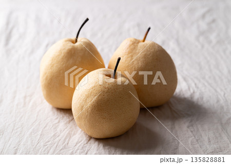 Fresh Asian pears on white wrinkled fabric with soft natural light Fresh Asian pears on white wrinkled fabric with soft natural light 135828881