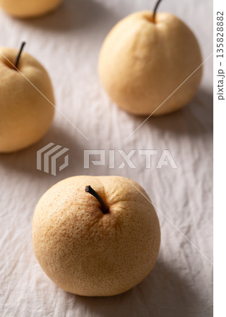 Fresh Asian pears on white wrinkled fabric with soft natural light 135828882