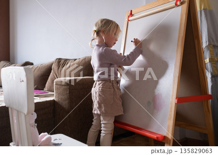 Little Girl Writing Numbers on Whiteboard with Marker. Little Girl Writing Numbers on Whiteboard with Marker. 135829063