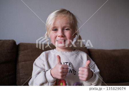 Little girl, 4 years old, showing thumbs up 135829074