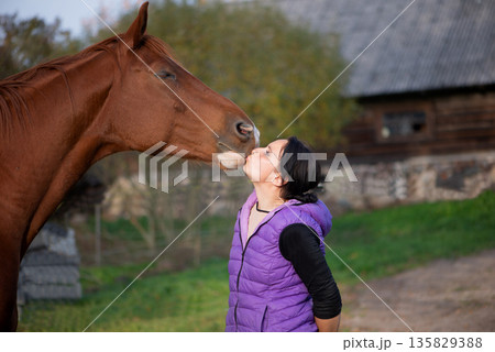 Gentle Moment Between Woman And Horse Outdoors Gentle Moment Between Woman And Horse Outdoors 135829388