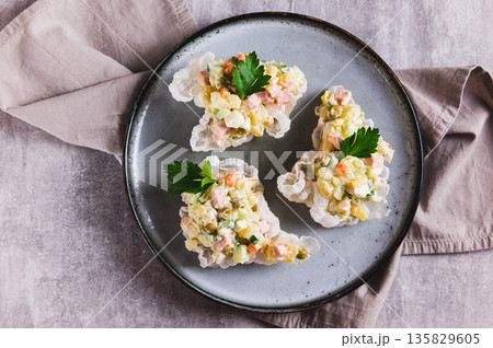 Close up of portioned Olivier salad creatively served on a plate on the table top view Close up of portioned Olivier salad creatively served on a plate on the table top view 135829605