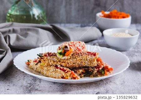 Cucumbers and Korean carrots wrapped in crab meat and fried with sesame seeds on a plate Cucumbers and Korean carrots wrapped in crab meat and fried with sesame seeds on a plate 135829632
