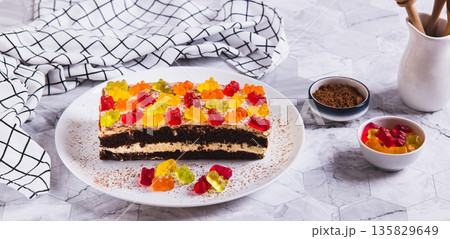 Chocolate cake decorated with gummy bears on a plate on a table web banner Chocolate cake decorated with gummy bears on a plate on a table web banner 135829649