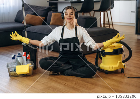 Keep calm, meditating. Female professional cleaning service worker is domestic room Keep calm, meditating. Female professional cleaning service worker is domestic room 135832200