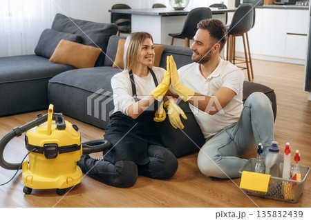 High five gesture. Two cleaning service workers are in domestic room 135832439