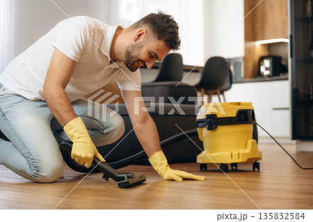 Cleaning the parquet. Male professional cleaning service worker is domestic room 135832584