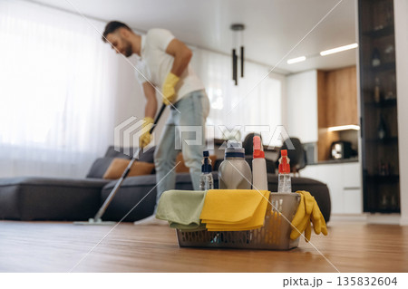Wet cleaning of the floor. Male professional cleaning service worker is domestic room Wet cleaning of the floor. Male professional cleaning service worker is domestic room 135832604