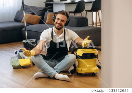 Yoga meditation. lotus pose. Male professional cleaning service worker is domestic room Yoga meditation. lotus pose. Male professional cleaning service worker is domestic room 135832623