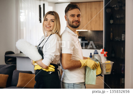 Home will be clean, standing, ready. Two cleaning service workers are in domestic room Home will be clean, standing, ready. Two cleaning service workers are in domestic room 135832656