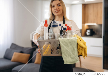 Bunch of chemicals in bottles. Female professional cleaning service worker is domestic room 135832777