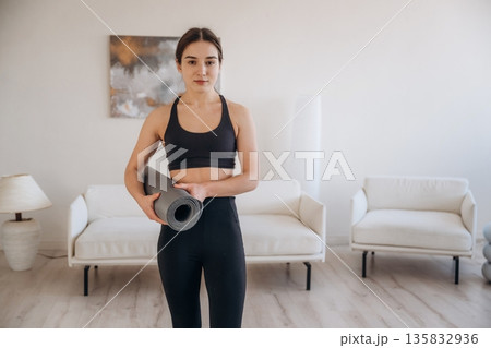 In domestic room. Yoga woman is at home with mat In domestic room. Yoga woman is at home with mat 135832936