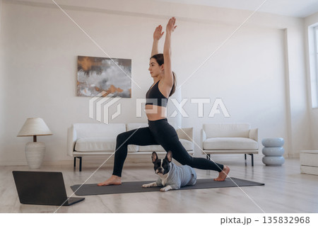 Endurance exercise. Woman with pug dog is doing yoga at home Endurance exercise. Woman with pug dog is doing yoga at home 135832968