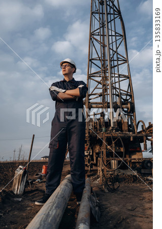 Water pipes are on the ground. Construction worker is near boring drilling machine Water pipes are on the ground. Construction worker is near boring drilling machine 135833169