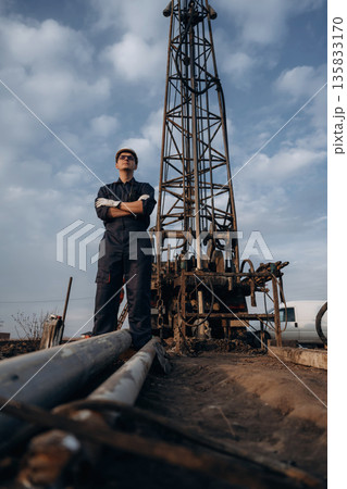 Water pipes are on the ground. Construction worker is near boring drilling machine Water pipes are on the ground. Construction worker is near boring drilling machine 135833170