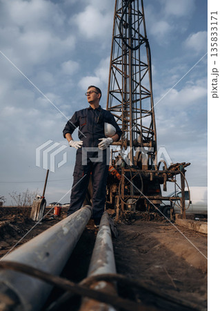 Water pipes are on the ground. Construction worker is near boring drilling machine 135833171