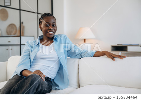 Looking forward, sitting and smiling. Woman is at home in domestic room 135834464